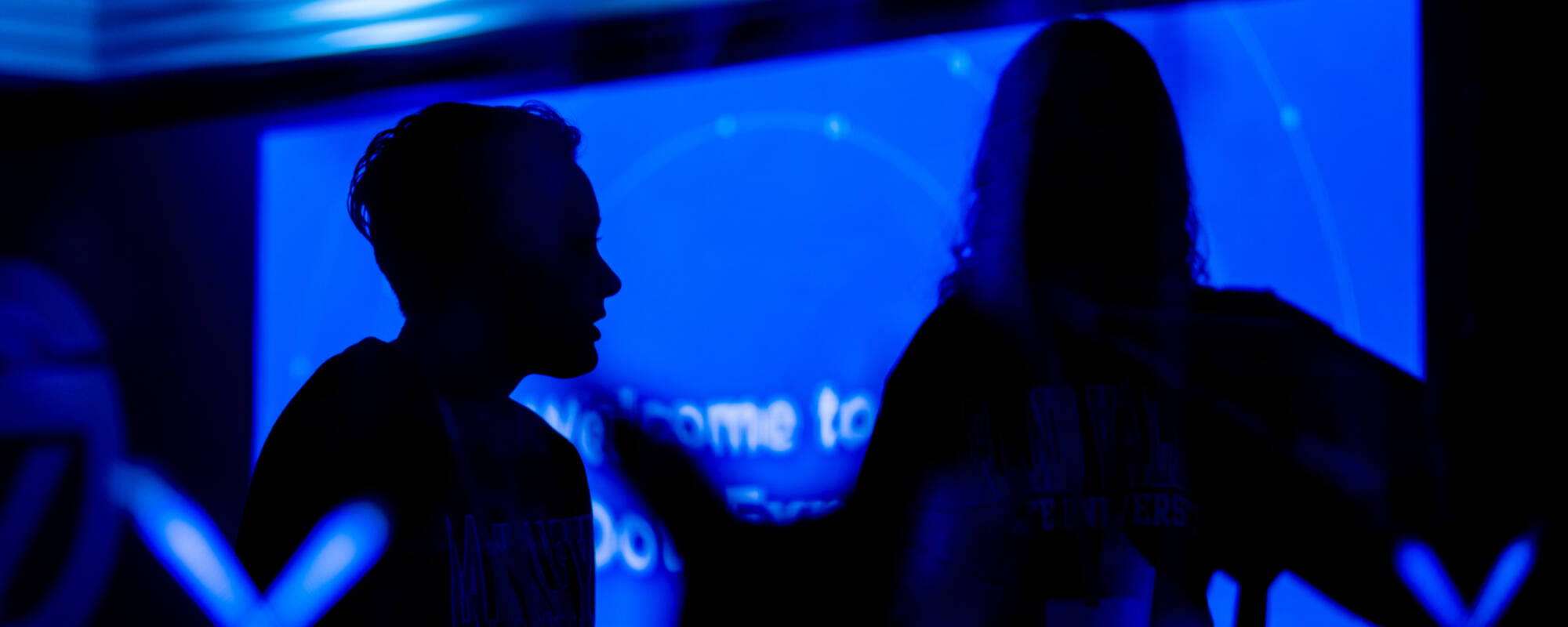 A silhouetted person with a blue screen in the background.